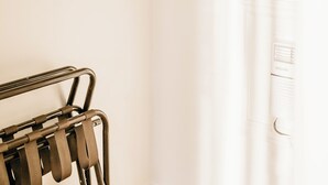 A bathroom with a towel rack, a hanging clothes rack, and a towel shelf. - Aurora Inn (Kingston)