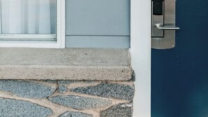 A house number '9' on a blue door, a glass door with a white frame, and a stone step leading to the door.