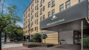 A hotel entrance with a sign for 4400 Connecticut Avenue, Days Inn logo, and a flag.