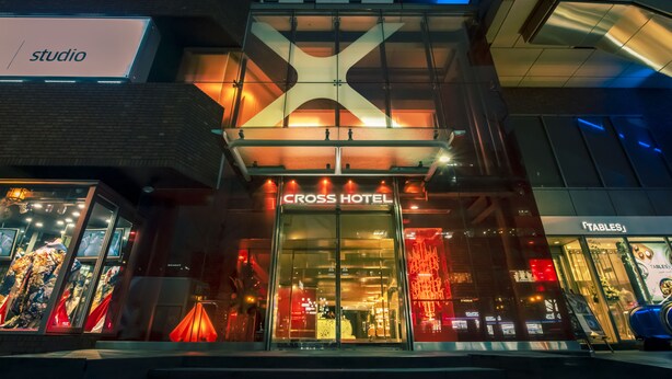 The exterior of the Cross Hotel with a glass facade and illuminated signage. - Cross Hotel Osaka(ORIX HOTELS & RESORTS) (Osaka)