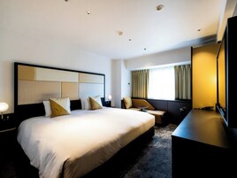 Una habitación de hotel moderna con una cama grande, un escritorio, una silla y un televisor.