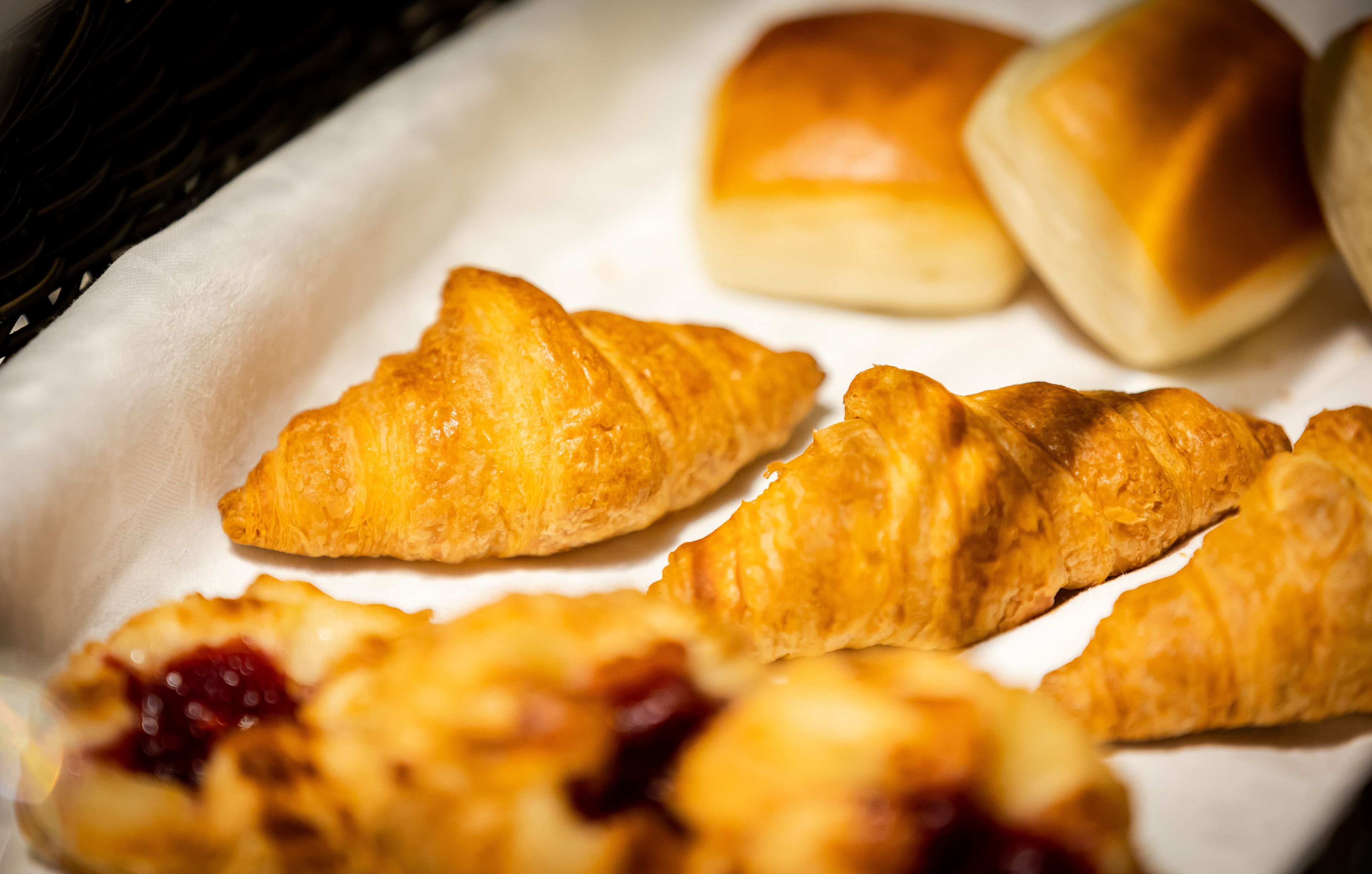 Una bandeja con pasteles, incluyendo croissants y bollos.