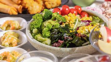 A variety of dishes including a salad bowl, shrimp, and other food items.