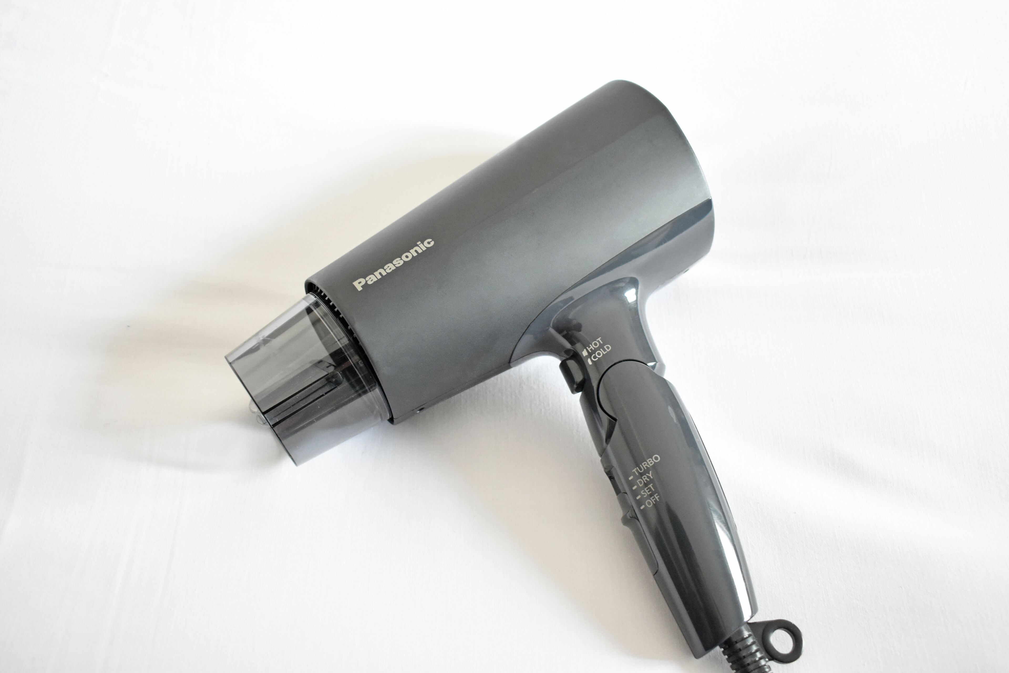 A Panasonic hair dryer with a transparent nozzle and a black handle.
