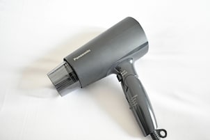 A Panasonic hair dryer with a transparent nozzle and a black handle.