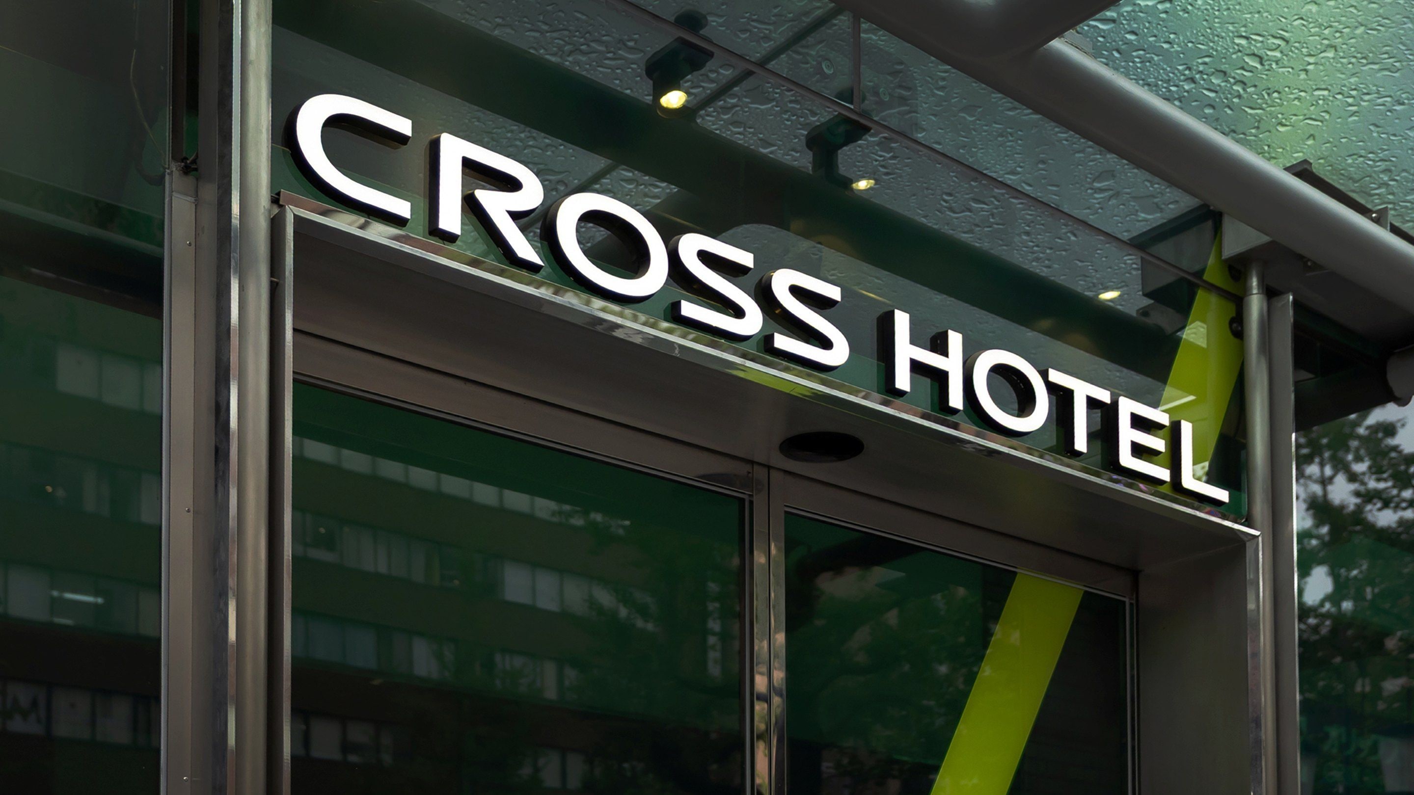 Un letrero de hotel con el nombre 'CROSS HOTEL' en letras grandes y negritas.