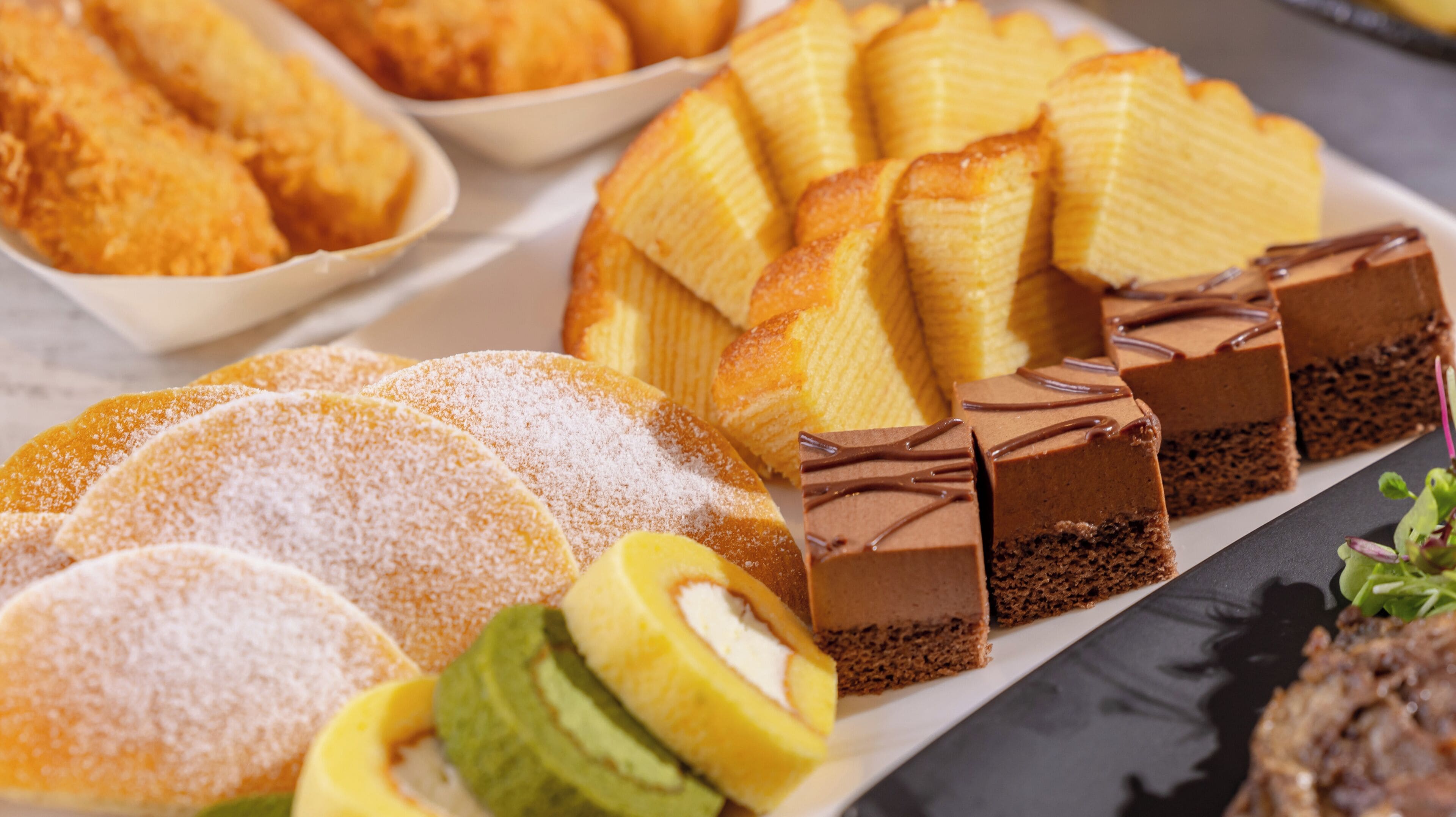Diversos postres, incluyendo pasteles, bollería y un postre de chocolate con capas.
