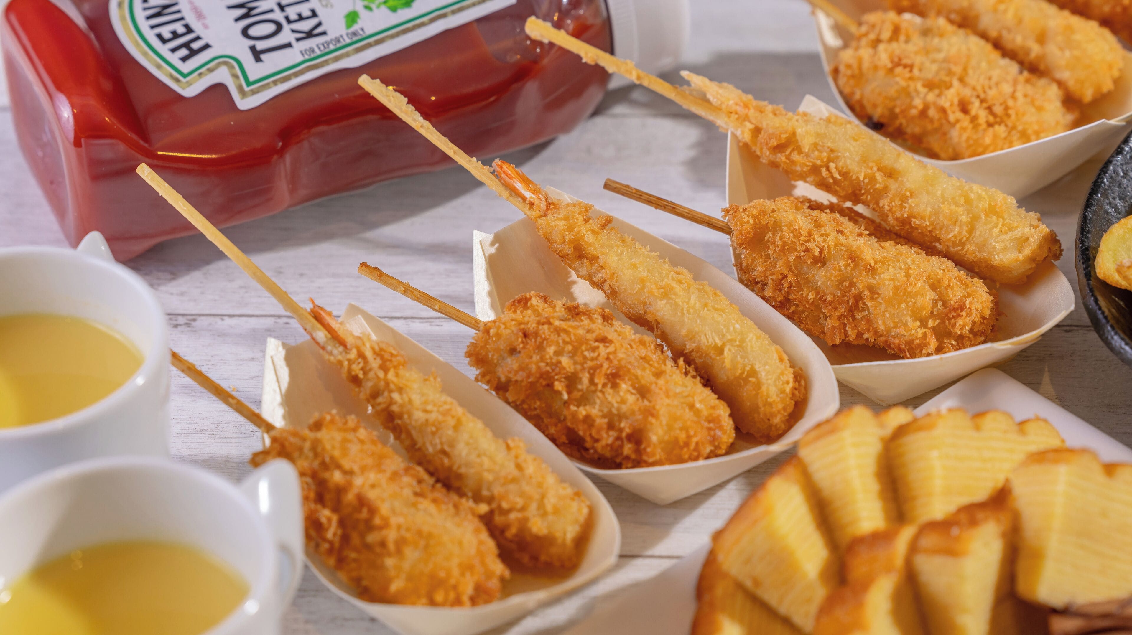 A table with food items, including breaded sticks and dipping sauces.