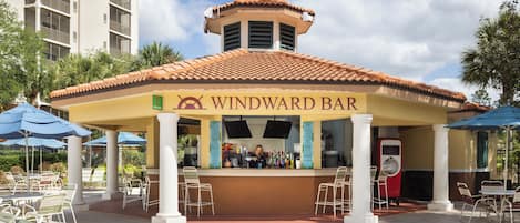 A Windward Bar with a tiled roof, outdoor seating, and a bar area.