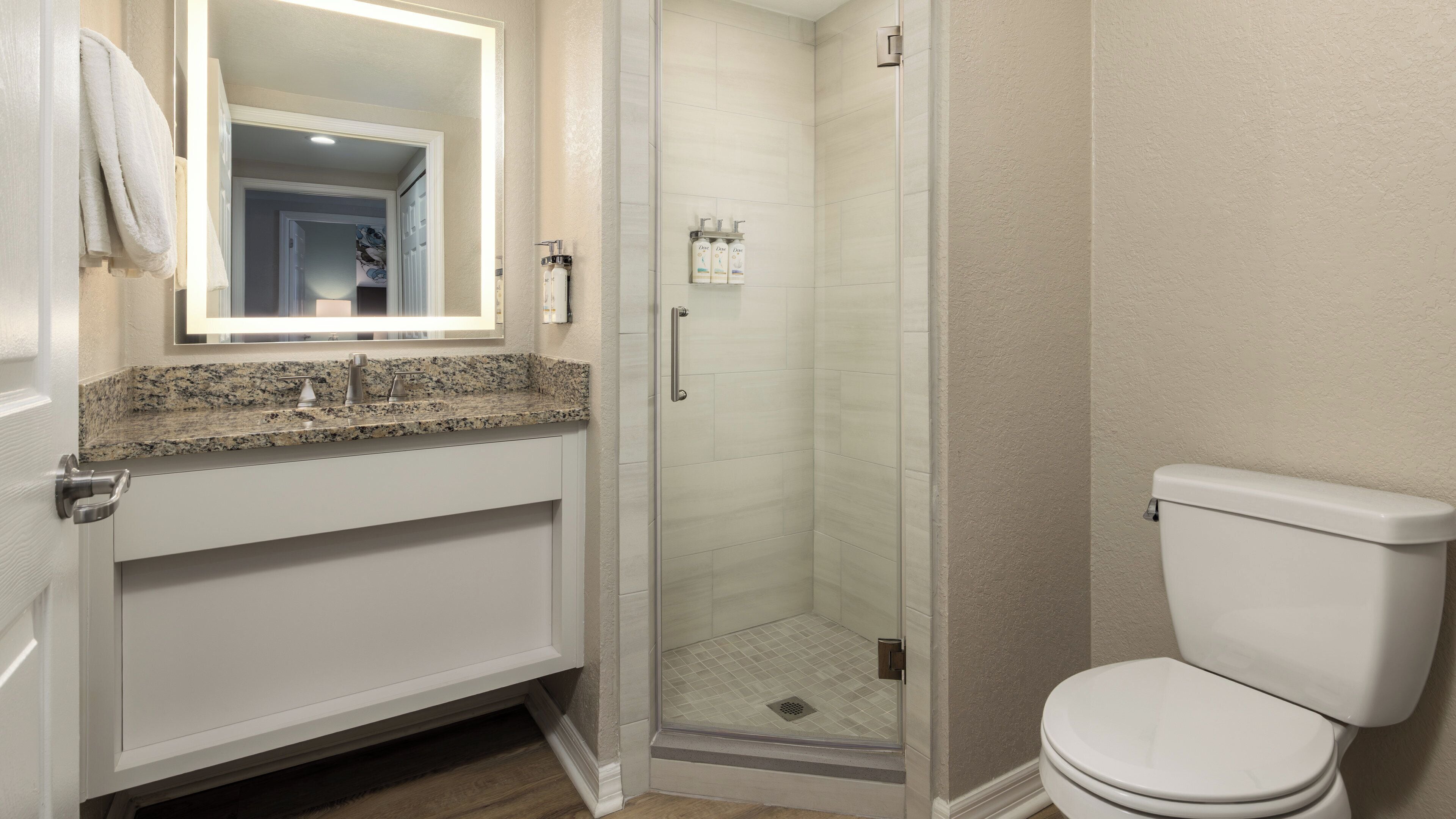 A bathroom with a shower, toilet, and sink.
