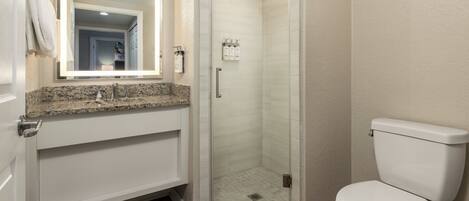 A bathroom with a shower, toilet, and sink.