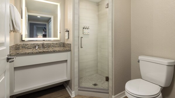 A bathroom with a shower, toilet, and sink.