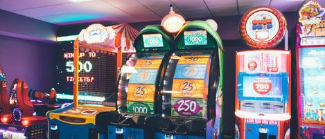 A row of arcade machines with prize screens, including a 'Quiz Doo' and a 'Jackpot' game.