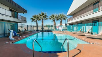 Una piscina al aire libre de temporada, sillones reclinables de piscina