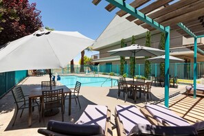 Una piscina al aire libre de temporada, sillones reclinables de piscina