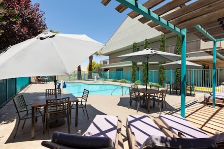 Una piscina al aire libre de temporada, sillones reclinables de piscina