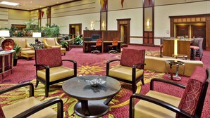 A spacious lobby with multiple seating areas, including chairs and sofas, and a central table with a decorative bowl. - Columbus Airport Marriott (Columbus)