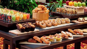 A buffet table with various pastries, donuts, and fruit juices. - Columbus Airport Marriott (Columbus)