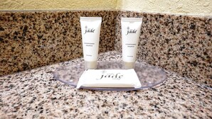 Two jade conditioning shampoo tubes on a granite countertop with a jade soap box.