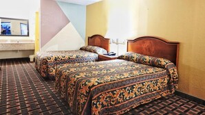A hotel room with two beds, a bathroom, and a TV.