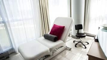 Guests can relax on the examination table with a footrest and pillow, while a comfortable office chair is nearby.