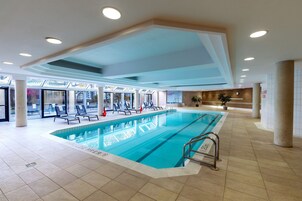 Una piscina interior con sillas de descanso y tragaluces.