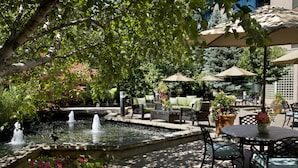 An outdoor patio area with a fountain, seating, and umbrellas. - Hilton Toronto/Markham Suites Conference Centre & Spa (Markham)