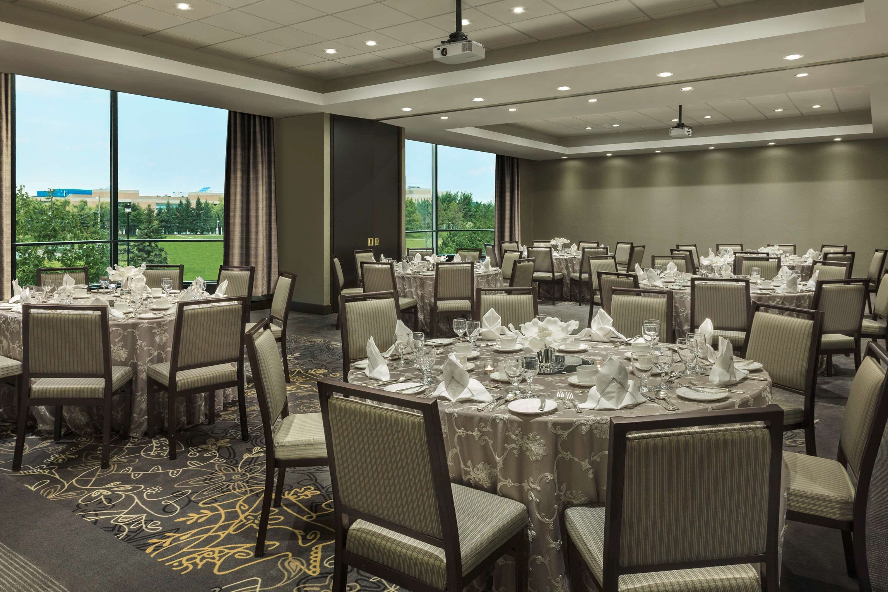 A conference room with round tables, chairs, and a projector.