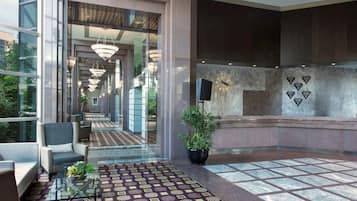 Un hall d’entrée moderne avec un tapis à motifs, un espace salon et un comptoir d’accueil.