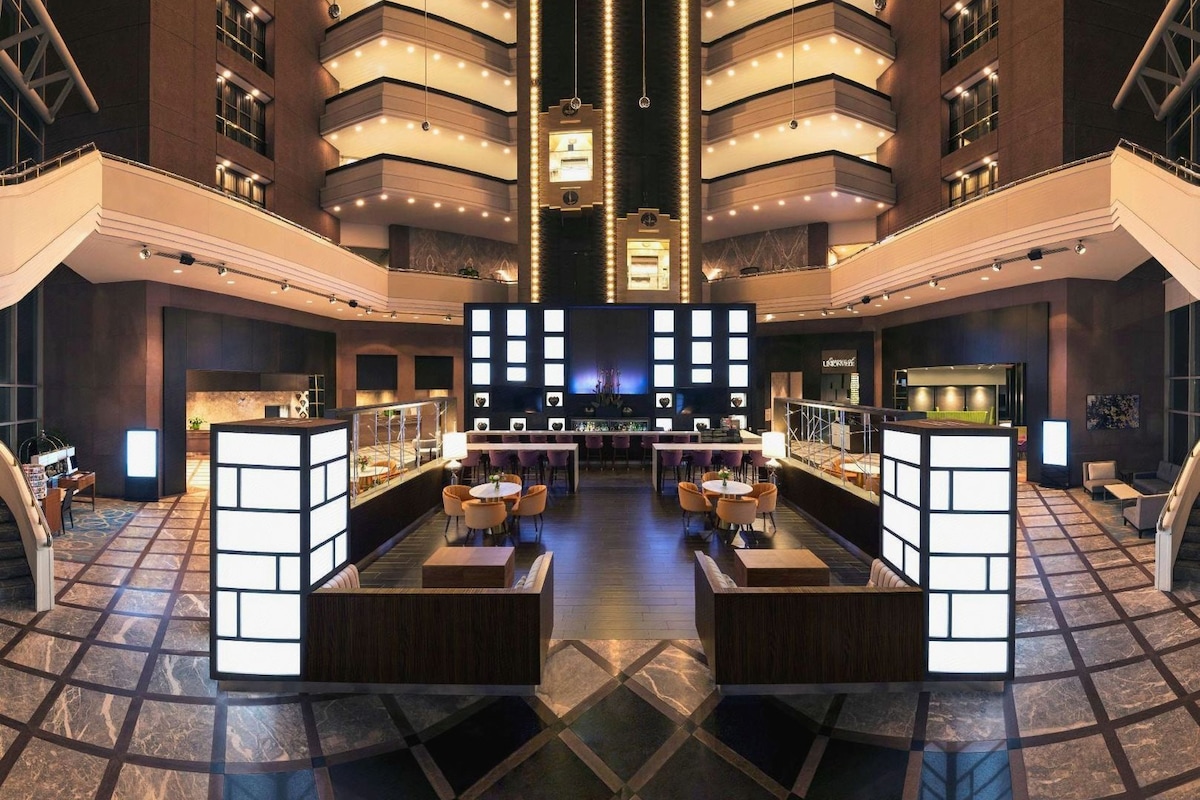 A spacious lobby with a central seating area, multiple floors, and a modern design.