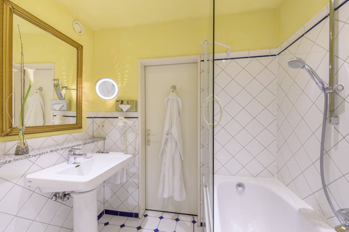 Ein Badezimmer mit Waschbecken, Spiegel und Badewanne.