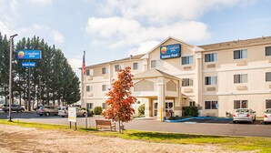 A Comfort Inn hotel with an indoor pool, a parking lot, and a flagpole.