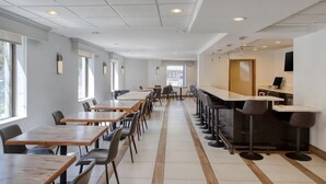 A modern dining area with long tables, chairs, and a bar area. - Best Western Gregory Hotel (Brooklyn)