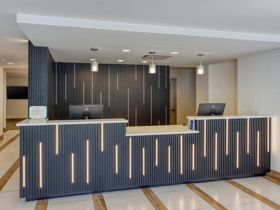 En receptionsdisk med et moderne design, med lodrette lysbånd og en plan overflade.