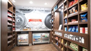 A store interior with shelves stocked with snacks and beverages, a refrigerated display case, and a wall with a 'TREATS' sign. - Hampton Inn Egg Harbor Township Atlantic City (Egg Harbor Township)