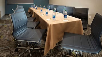 A conference room with a long table, several chairs, and water bottles on the table.