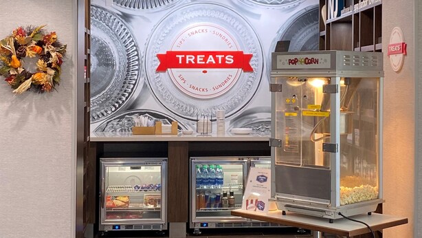 A food service area with a 'Treats' sign, a popcorn machine, and refrigerated display cases. - Hampton Inn Egg Harbor Township Atlantic City (Egg Harbor Township)