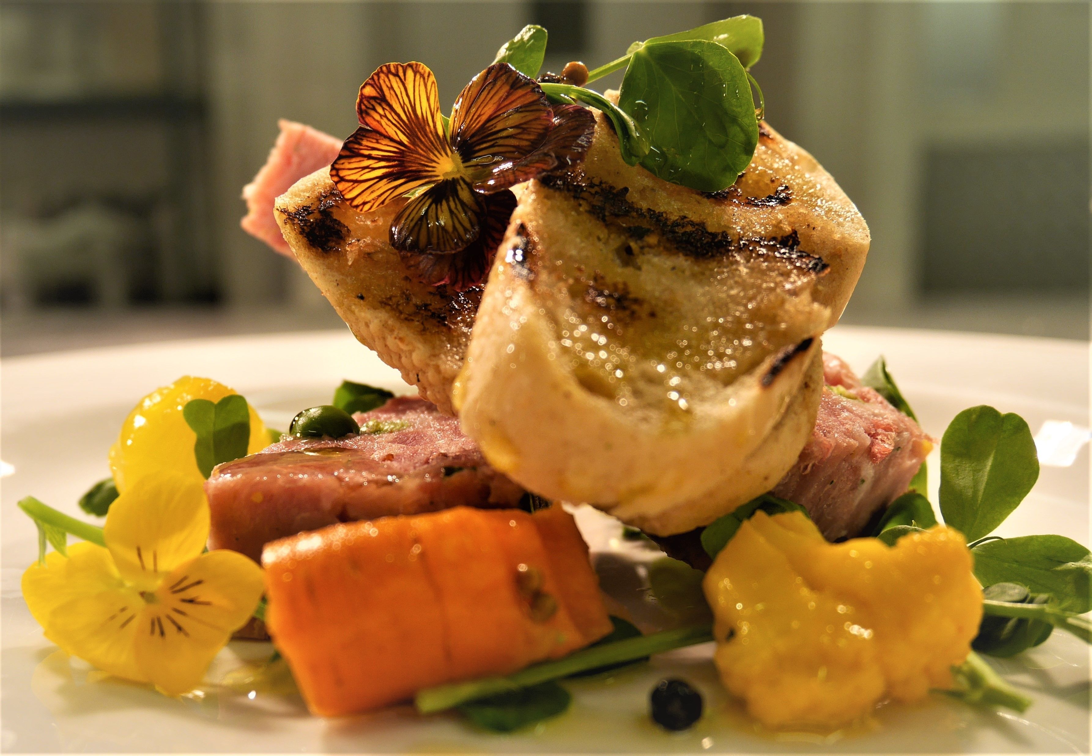 A plated dish with various vegetables and garnishes.