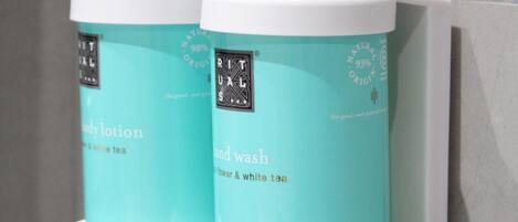 Two hand wash bottles with pumps, labeled 'Rituals' and 'Hand wash', mounted on a wall.