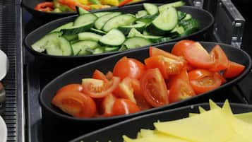 Un bufé con diferentes verduras en rodajas.
