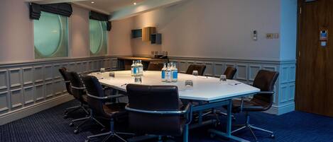 A conference room with a large table, chairs, and water bottles.