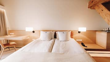 A hotel room with a bed, bedside tables, a desk, a chair, and a telephone.