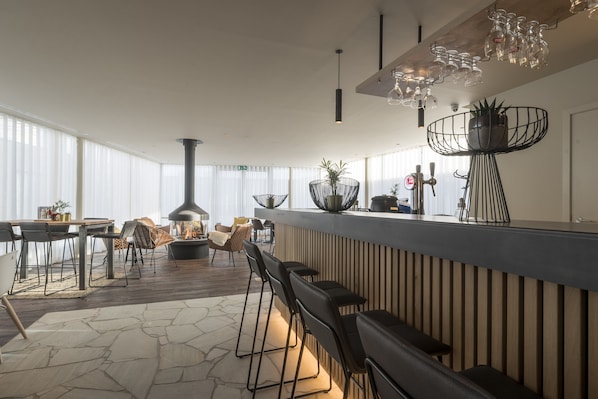 Una cocina moderna con barra, suelo de madera y ventanas amplias.