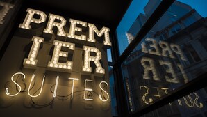 Illuminated signage for "PREMIER SUITES" with a view of buildings in the background. - PREMIER SUITES PLUS Antwerp (Antwerp)