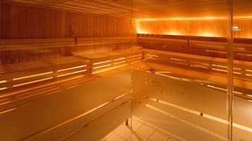 Un sauna avec des bancs en bois et une paroi en verre.