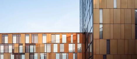 A modern building with a grid of windows and a mix of glass and metal paneling.