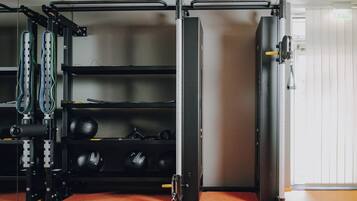 Une salle de sport équipée de matériel de musculation, d’une barre de traction et d’une porte.