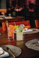 Una mesa de restaurante con dos bebidas, un cuchillo y una servilleta.