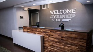 A reception desk with a 'Welcome to the Volunteer State' sign, a wooden panel design, and a 'Hilton' sign. - Hampton Inn Pickwick Dam-At Shiloh Falls (Counce)