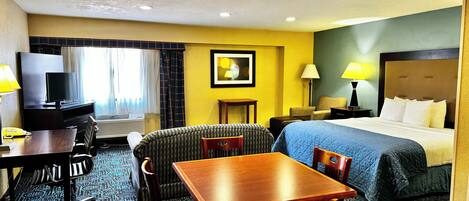 A hotel room with a bed, a desk, a chair, a television, a lamp, and a painting on the wall.